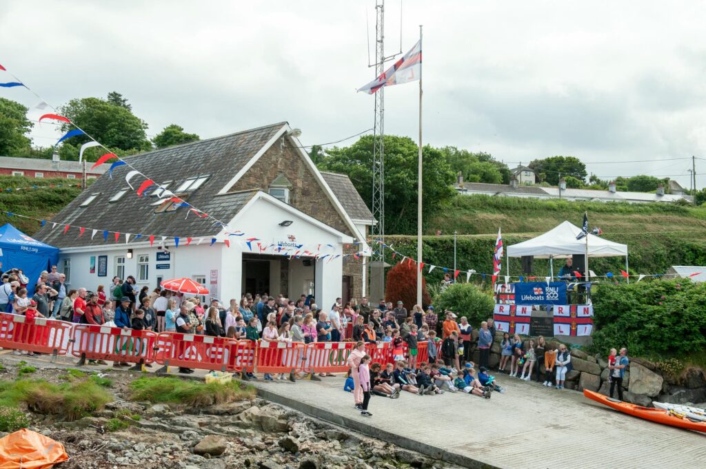 RNLI Helvick Lifeboat Station with crowd of supporters - Helvick Swim 2024